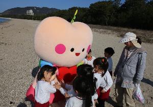 きゅっとちゃんと園児たちが虹ケ浜海岸で触れ合っています