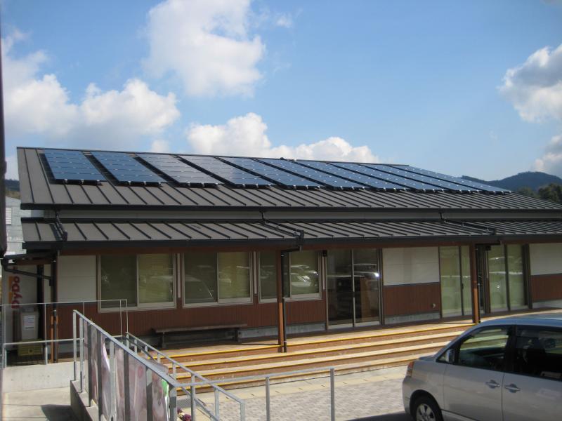体験研修棟の屋根についている太陽光発電設備と体験研修棟の入り口の写真