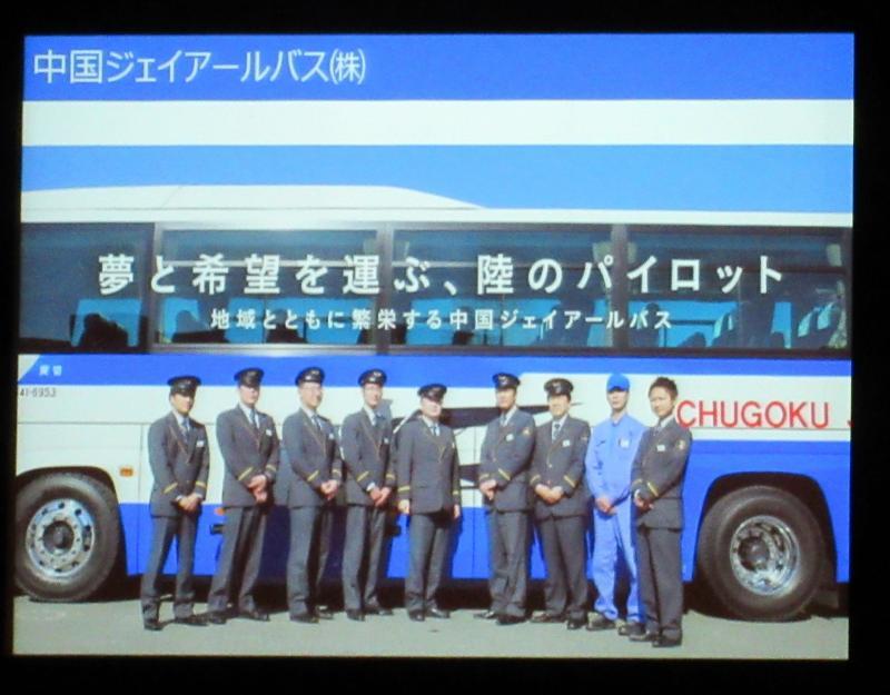 青と白のバスを背景に制服姿の乗組員男性たちが写っている写真