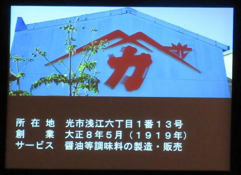 赤いロゴマークが大きく掲げられた河村醤油株式会社の建物外観の写真