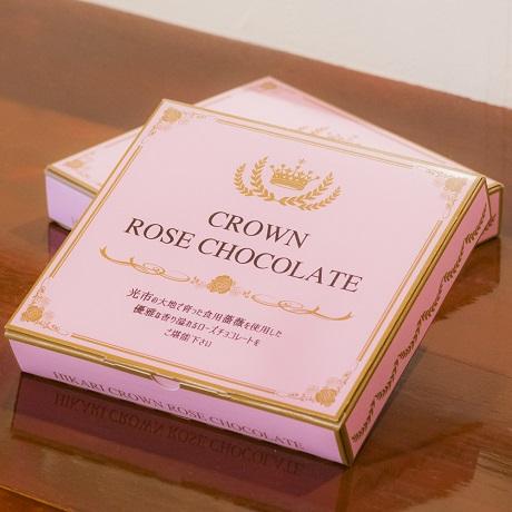 ピンク色の箱に金の縁取りと商品名が書かれた光クラウンローズチョコレートのパッケージの写真