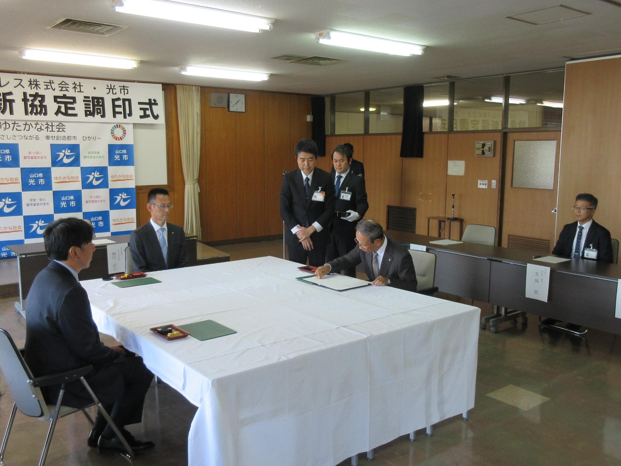 調印式で市川市長が協定書に調印している様子