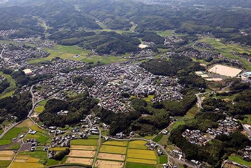 岩田駅周辺の田畑と、山、街並みの航空写真