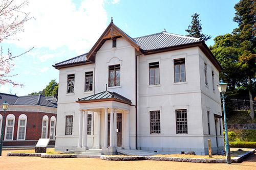 白い外壁で縦長の窓がある2階建ての旧伊藤 博文邸の写真